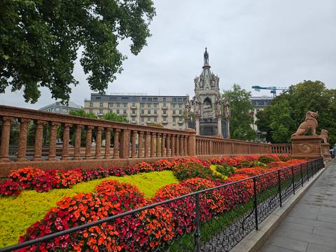 Vibrant flowerbeds line an ornate stone balustrade near the neo-Gothic Brunswick Monument in Geneva