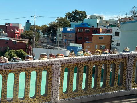 Colourful hillside houses and mosaic rail in Gamcheon Culture Village overlooking Busan.