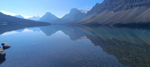 Mirror-calm alpine lake perfectly reflecting towering Rocky Mountains