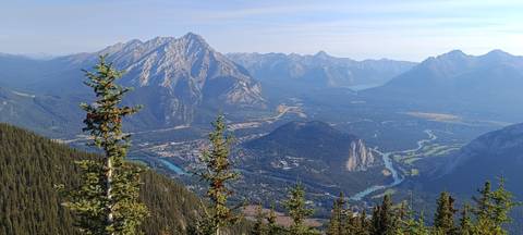 Panoramic summit view overlooking Banff townsite, rivers and towering peaks