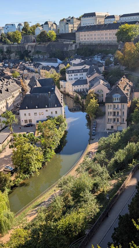 Aerial view of Luxembourg’s Grund district with calm river lined by historic buildings