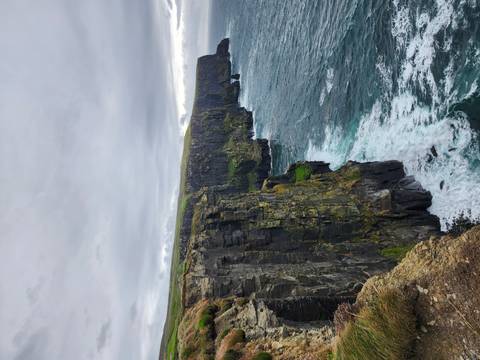 Dramatic Cliffs of Moher stretching along the Atlantic with waves crashing below