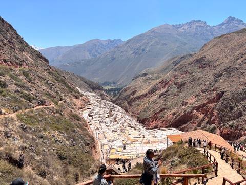 Broad view over the white terraced salt ponds of Maras set in a rugged Andean valley.