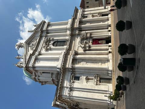 Tall baroque-style cathedral facade in bright daylight with clear architectural details and blue sky background.