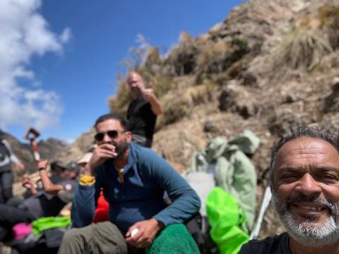 Blurred selfie during a mountain break with trekkers resting on rocky terrain.