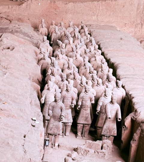 Rows of life-sized Terracotta Warrior statues inside an excavated pit