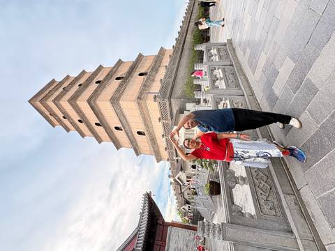 Two travelers posing playfully in front of the Giant Wild Goose Pagoda