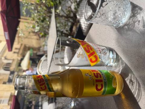 Chilled bottle and glass of Cisk beer on an outdoor café table in Malta