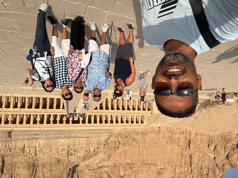 Selfie of guide and tourists in front of the terraced façade of Hatshepsut Temple in Luxor