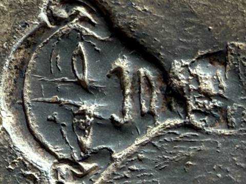 Macro photograph of a weathered stone carving of an ancient Egyptian face showing surface cracks.