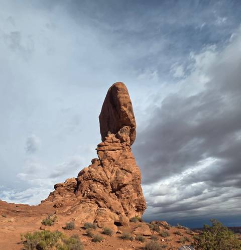 The famous Balanced Rock stands precariously against a moody sky in Arches National Park.