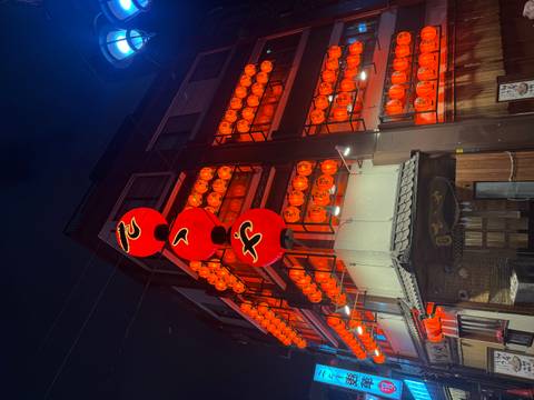 Traditional building illuminated by dozens of red lanterns glowing in the night.