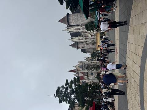 Theme-park style European castle buildings bustling with visitors under grey sky