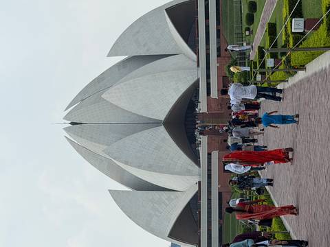 Crowds approach the white petal-shaped Lotus Temple in New Delhi on a hazy day