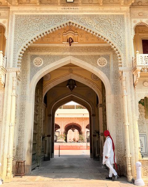 Ornate marble archway with intricate carvings leading into an inner courtyard