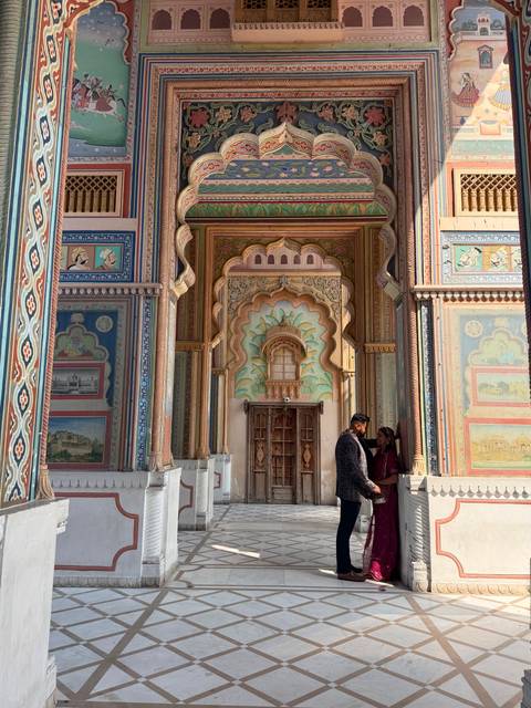 Colorful, highly decorated Patrika Gate with a couple posing at the entrance
