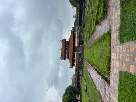Historic wooden gatehouse of the Imperial City in Hue framed by stone walls under a grey sky