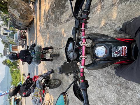 Rider’s POV from a scooter handlebar following fellow motorbikes on a rural road