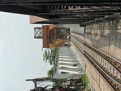 Perspective view down the Long Bien railway bridge in Hanoi with tracks stretching into the distance.