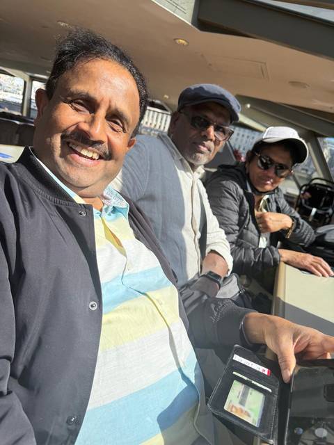 Selfie of three travelers seated on a boat enjoying sunny weather.