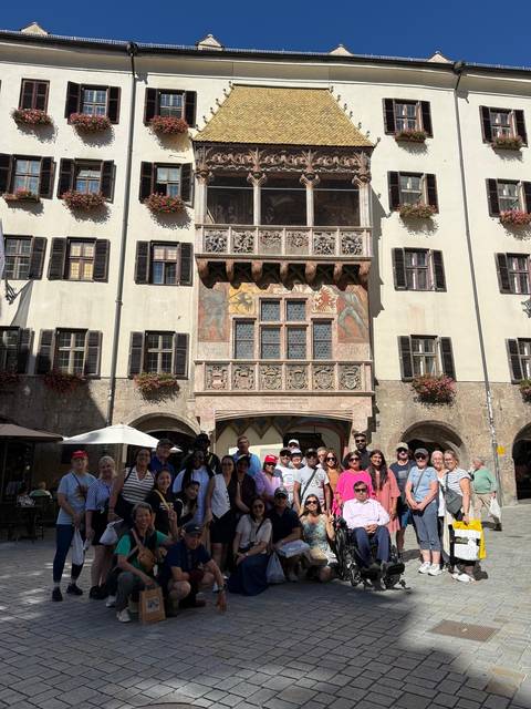 Tour group posing in front of the Golden Roof building in Innsbruck.