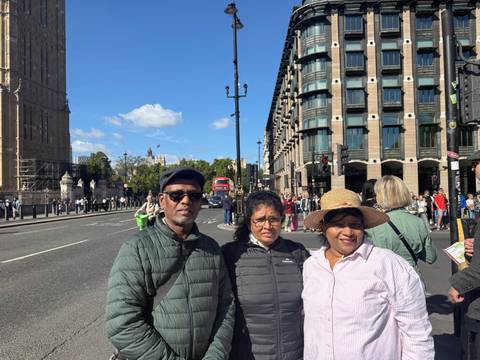 Three travelers standing on Westminster Bridge with Big Ben renovation scaffolding behind.