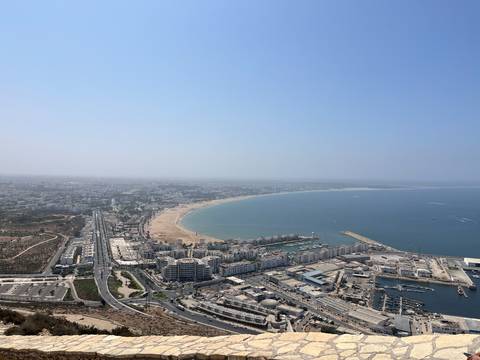 Aerial panorama of Agadir’s curving beach, marina and city stretching along the Atlantic coast.