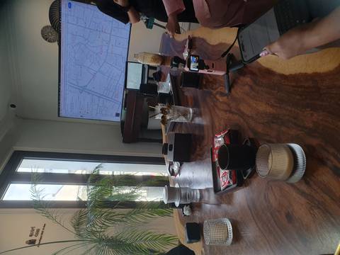 Modern meeting table with coffees and a large wall screen displaying a city map.