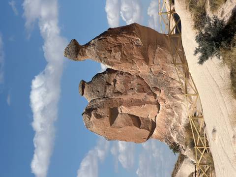 Distinctive camel-shaped rock pillars set against a bright sky in Cappadocia.