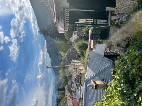Mountain village rooftops and wooded ridges under a sky of scattered clouds in northern Greece