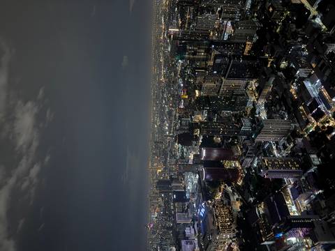Panoramic night view over Bangkok's illuminated skyline with countless skyscrapers.