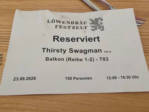 Reservation sign for Löwenbräu Festzelt detailing date, time, and group size.