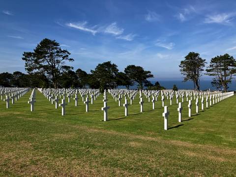 Rows of white crosses at the Normandy American Cemetery overlooking the sea.