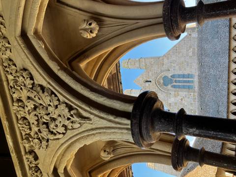 Ornate stone arch framing the abbey church inside Mont Saint-Michel cloisters.