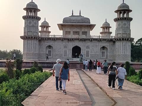Tourists stroll the marble walkways of Itimad-ud-Daulah’s Tomb, Agra, ornamented with intricate inlay work at dusk.