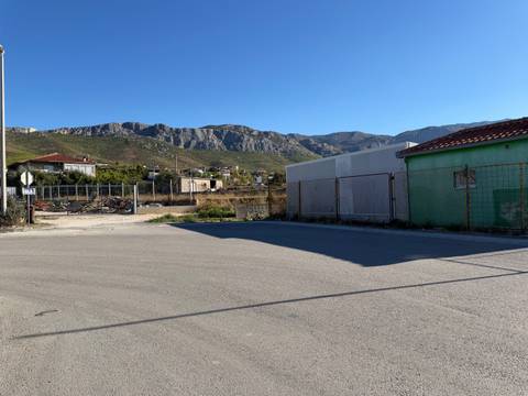 Rural industrial lot with distant mountain ridge under clear sky.