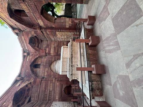 Intricately carved red sandstone tomb inside the Qutub complex.