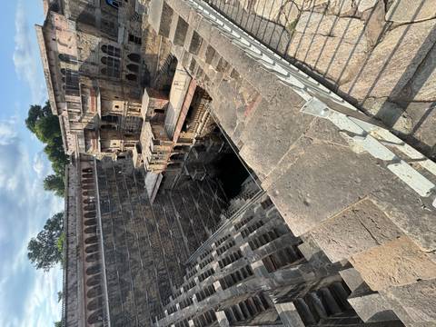 Deep multi-level stepwell with symmetrical stone stair patterns.