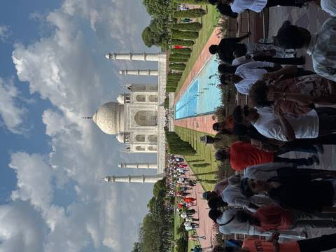 Iconic frontal view of the Taj Mahal with reflecting pool and large crowds.