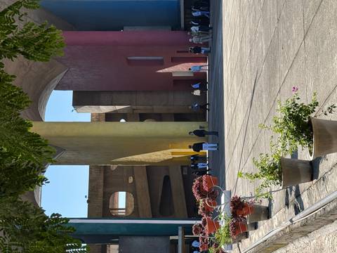 Visitors gather in the colourful colonnaded courtyard of Chandigarh’s High Court complex with bold yellow and red walls.