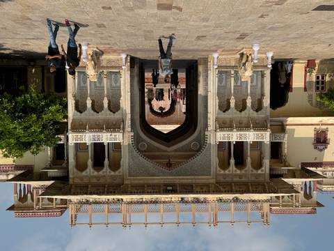 Intricately carved gateway of Jaipur City Palace with marble elephants and visitors walking through the arch.