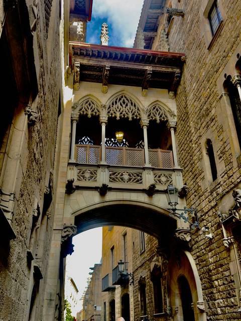 Stone alley with the ornate neo-Gothic Bridge of Sighs style balcony overhead.