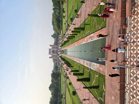 Symmetrical view down the long reflecting pool toward the grand entrance gate of the Taj Mahal complex.