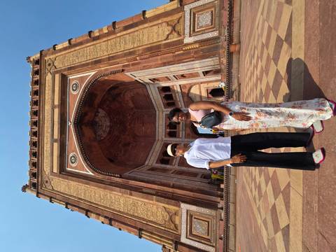 Two women stand below the towering Buland Darwaza gate at Fatehpur Sikri.