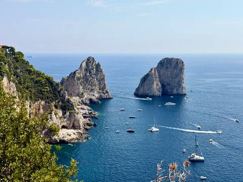 Boats cruise around the dramatic Faraglioni sea stacks off Capri’s rugged coast.