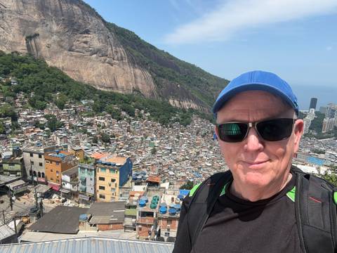 Traveller selfie overlooking a sprawling favela and granite cliffs in Rio de Janeiro.