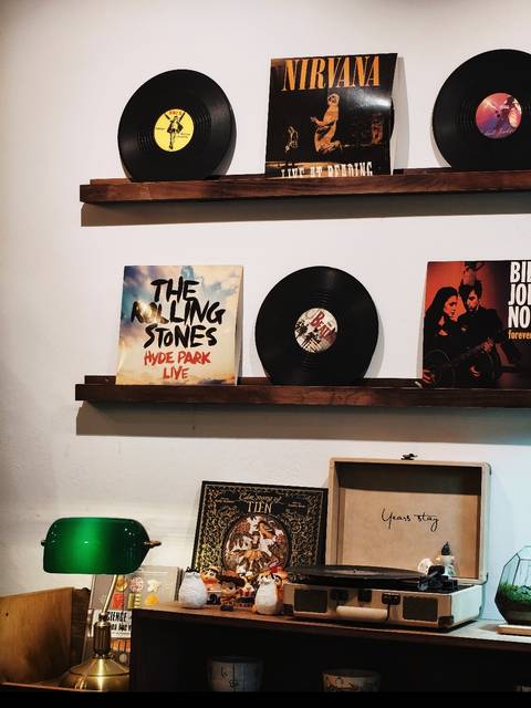 Shelf display featuring a vinyl record and Rolling Stones album cover against a white wall.