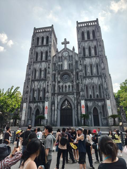 Front view of the imposing gray stone façade of St. Joseph’s Cathedral under bright daylight.