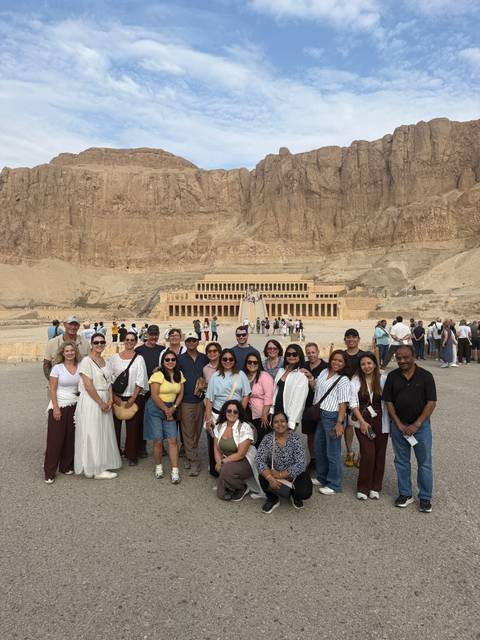 Group photo in front of the monumental Temple of Hatshepsut carved into desert cliffs.