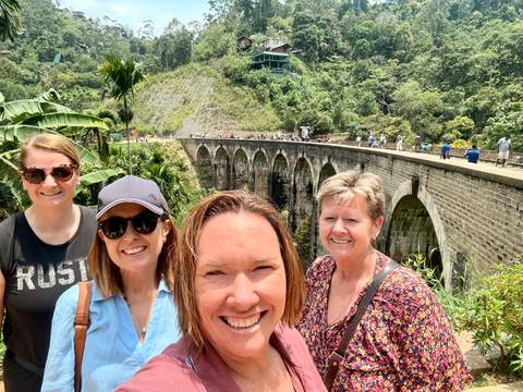 Selfie with four women at the famous Nine Arches Railway Bridge amid lush hills.